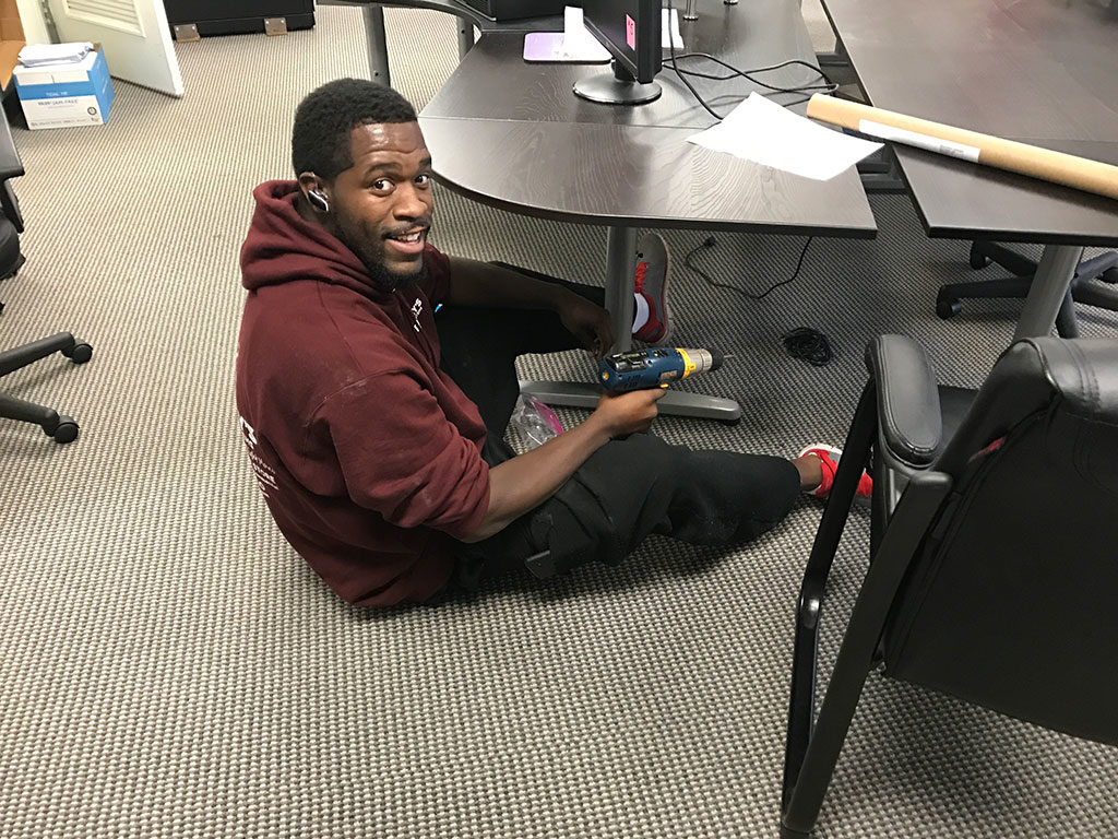 Ramsey crew member configuring a desk