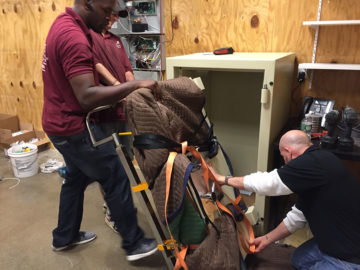 It takes a crew to make sure the heavy safe door is hinged correctly.