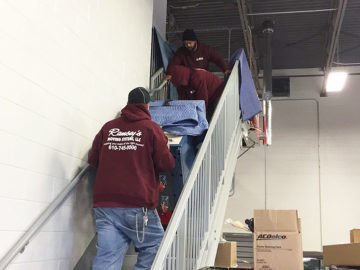 A few of our guys navigate this bulky cabinet down the stairs.