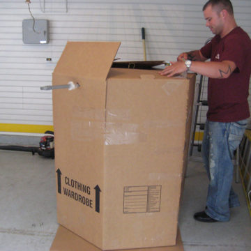 There is an art to packing boxes. Here our mover assembles a waredrobe box to easily transport hanging clothing.