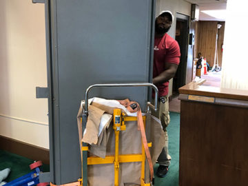 A team member stands behind the door to cart it through the building.