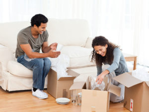 Two people packing glasses into a box