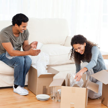 Two people packing glasses into a box