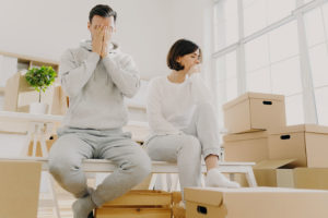 Couple looking stressed around moving boxes