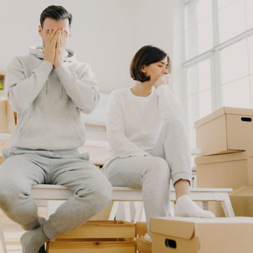 Couple looking stressed around moving boxes