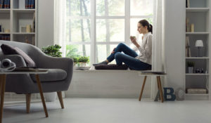 Girl sitting by window of a cozy house