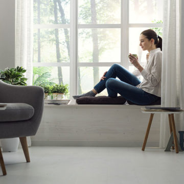 Girl sitting by window of a cozy house